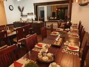 a dining room with wooden tables and chairs and a kitchen at Hotel Garni Kröger in Wittmund