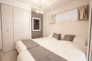 - une chambre avec un grand lit blanc et un placard dans l'établissement Premiere N21 / Vacation STAY 7452, à Sapporo