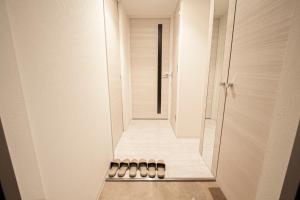 um corredor de uma casa de banho com uma cabina de duche ao nível do chão em Premiere N21 / Vacation STAY 7450 em Sapporo