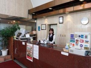 a woman sitting at a counter in a restaurant at Sky Heart Hotel Kawasaki / Vacation STAY 80807 in Kawasaki