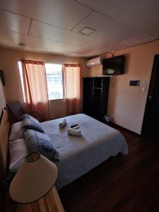 a bedroom with a bed with two towels on it at Toucan Hostel in Alajuela City