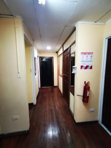 an empty hallway in an office building with a fire extinguisher at Toucan Hostel in Alajuela City
