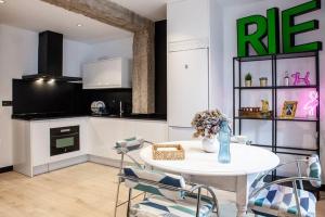 a kitchen with a white table and chairs in a room at LOFT MON in Zaragoza