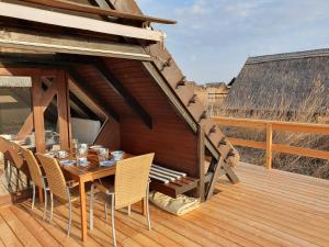 a wooden table and chairs on a wooden deck at Mountains and Lakes - Romantika 5 Beach Bungalow in Rust