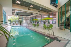 a pool in a building with chairs and umbrellas at Rosedale on Robson Suite Hotel in Vancouver