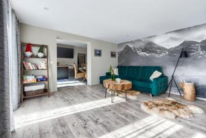 a living room with a green couch and a table at Domek - Apartament Góralska Bajka, przy Krupówkach in Zakopane