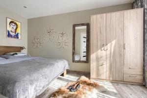 a bedroom with a bed and a large wooden cabinet at Domek - Apartament Góralska Bajka, przy Krupówkach in Zakopane