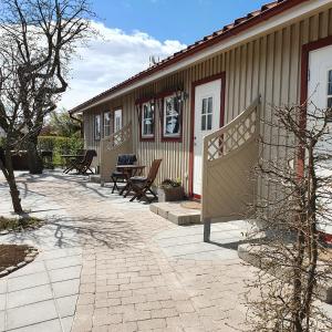 eine Terrasse eines Hauses mit einem Tisch und Stühlen in der Unterkunft B&B Villa Orion in Sölvesborg