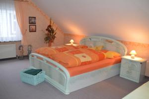 a bedroom with a bed with an orange and yellow comforter at Ferienhaus Linde am Bleßberg in Schirnrod