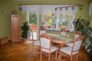 ein Esszimmer mit einem Tisch, Stühlen und einem Fenster in der Unterkunft Ferienhaus Linde am Bleßberg in Schirnrod