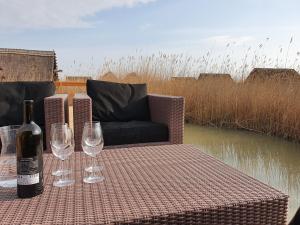 una mesa con copas de vino y una botella de vino en Mountains and Lakes - Romantika 5 Beach Bungalow, en Rust