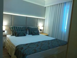 a hotel room with a large bed with blue pillows at Residencial Luxo Moema - Macuco in Sao Paulo