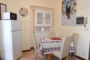 uma cozinha com uma mesa e um frigorífico branco em Camere Paolo em Assis