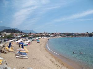 a beach with chairs and umbrellas and people in the water at Villa Orestis in Stoupa