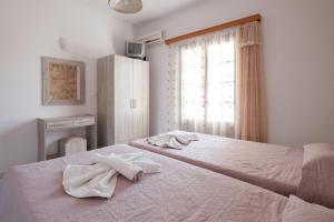 a bedroom with a bed with two towels on it at Hotel Club Maria Sidari in Sidari