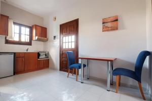 a kitchen with a wooden table and blue chairs at Hotel Club Maria Sidari in Sidari