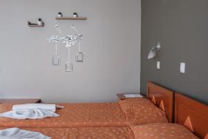 a bedroom with two beds and a white wall at Hotel Club Maria Sidari in Sidari
