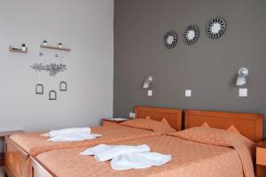 a bedroom with two beds with towels on them at Hotel Club Maria Sidari in Sidari