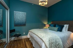ein blaues Schlafzimmer mit einem Bett und einem Stuhl in der Unterkunft 3rd Street Flats in McMinnville