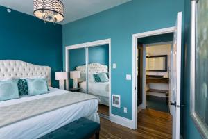 Dormitorio azul con cama y espejo en 3rd Street Flats, en McMinnville
