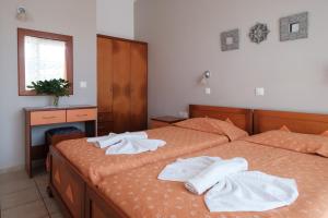 two beds with towels on them in a bedroom at Hotel Club Maria Sidari in Sidari