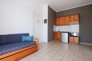 a living room with a couch and a kitchen at Hotel Club Maria Sidari in Sidari