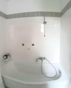 a white bath tub with a shower in a bathroom at bedroom@home in Berg bei Rohrbach