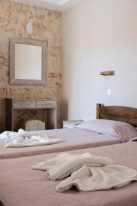a bedroom with two beds and a mirror on the wall at Hotel Club Maria Sidari in Sidari