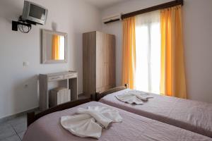 a bedroom with two beds with towels on them at Hotel Club Maria Sidari in Sidari