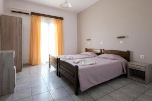a bedroom with two beds and a large window at Hotel Club Maria Sidari in Sidari