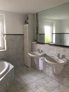 a bathroom with two sinks and a mirror at Rüsgen Ferienwohnung in Schwalmtal