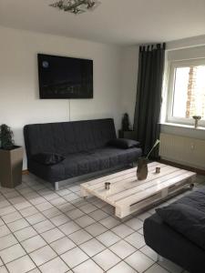 een woonkamer met een bank en een salontafel bij Rüsgen Ferienwohnung in Schwalmtal