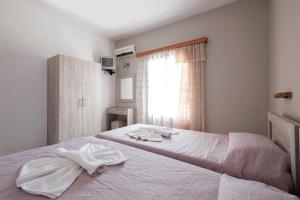 a bedroom with a bed with two towels on it at Hotel Club Maria Sidari in Sidari