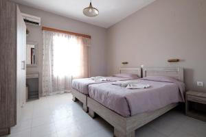 a bedroom with a bed with purple sheets and a window at Hotel Club Maria Sidari in Sidari