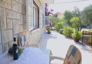 una bottiglia di vino seduta su un tavolo sul patio di Apartments Liza - 80 M from the sea a Korčula
