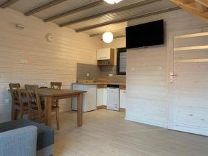 a kitchen and dining room with a table and a tv at Aparts Care Beztroska in Sianozety