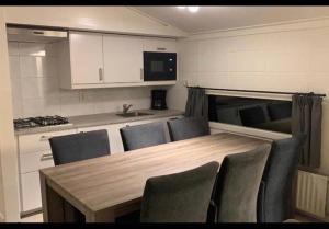 a kitchen with a table and chairs in a caravan at Bungalow 72 in Exloo