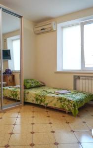 Zimmer mit 2 Betten und einem Spiegel in der Unterkunft Khoroshaya Kvartira Goloseevskaya 3 in Kiew