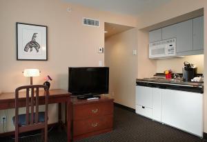 a kitchen with a television and a refrigerator at Rosedale on Robson Suite Hotel in Vancouver