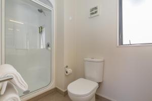a white bathroom with a toilet and a shower at Bella Vista Motel New Plymouth in New Plymouth +25 photos