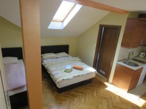 a bedroom with a bed and a sink and a skylight at Hotel Apartments Bella Mare Belgrade in Belgrade