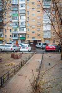 ein Parkplatz mit Autos vor einem Gebäude in der Unterkunft Квартира по улице Лескова, 6 in Kiew
