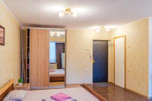 um quarto com uma cama e um quarto com um espelho em Квартира по улице Лескова, 6 em Kiev