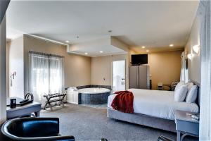 ein Hotelzimmer mit einem großen Bett und einer Badewanne in der Unterkunft Cumberland Court Motel in Hastings