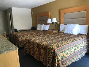 a hotel room with two beds and two lamps at Budget Inn Parker in Parker