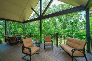 a screened in porch with chairs and a table at Hidden Meadows Bed and Breakfast in Stillwater
