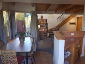 eine Küche und ein Esszimmer mit einem Tisch und einer Treppe in der Unterkunft Villa 10 - Central Stylish Apartment in Queenstown