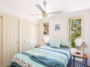 a bedroom with a bed and a ceiling fan at 1/4 Huntly Close in Tuncurry