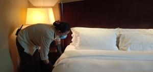 
two people standing in a room with a bed at Grand International Hotel in Guangzhou
