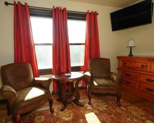 sala de estar con 2 sillas, mesa y TV en Hidden Meadows Bed and Breakfast en Stillwater